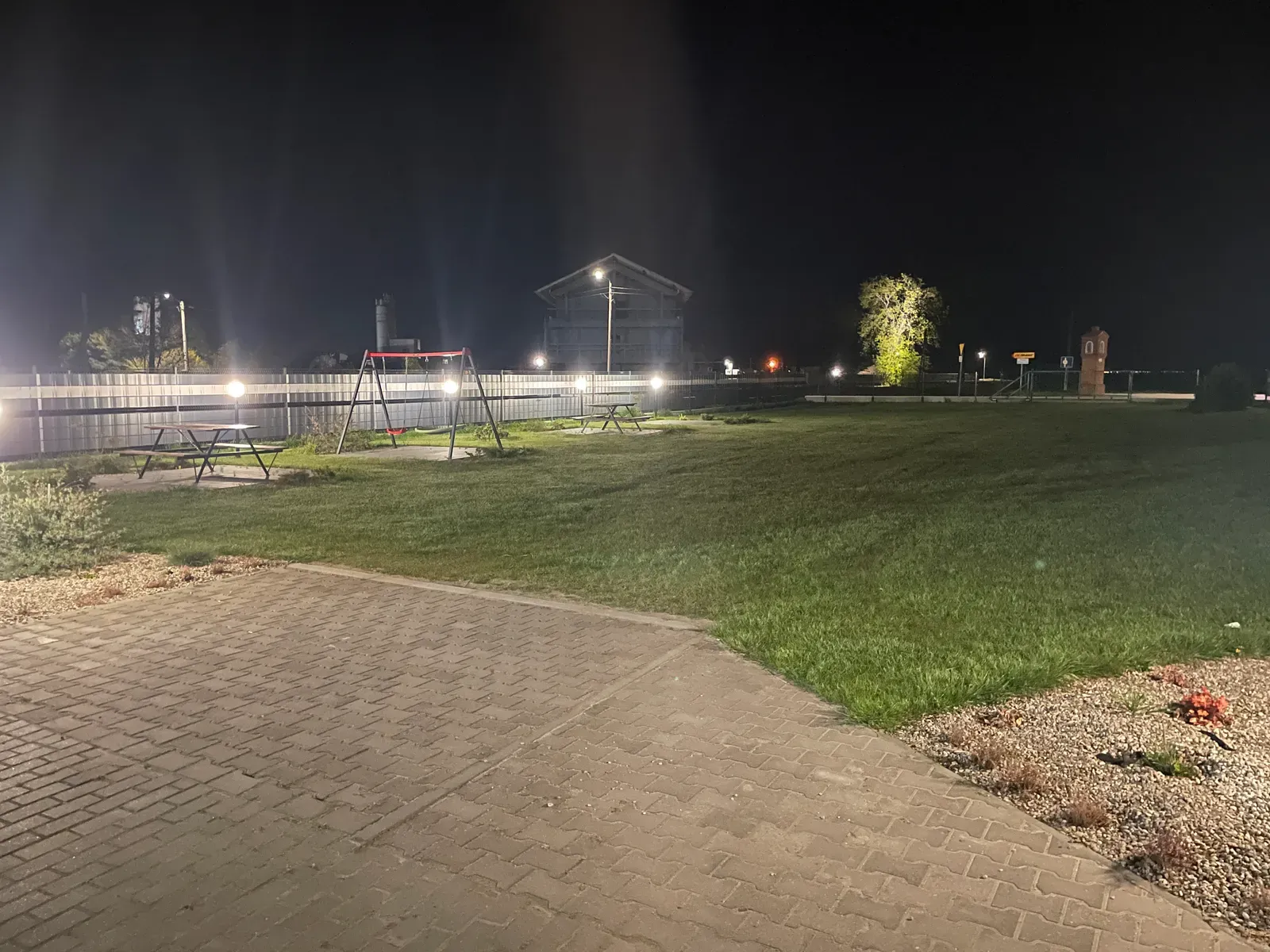 Teren zielony i lampy ogrodowe przy sali nocą