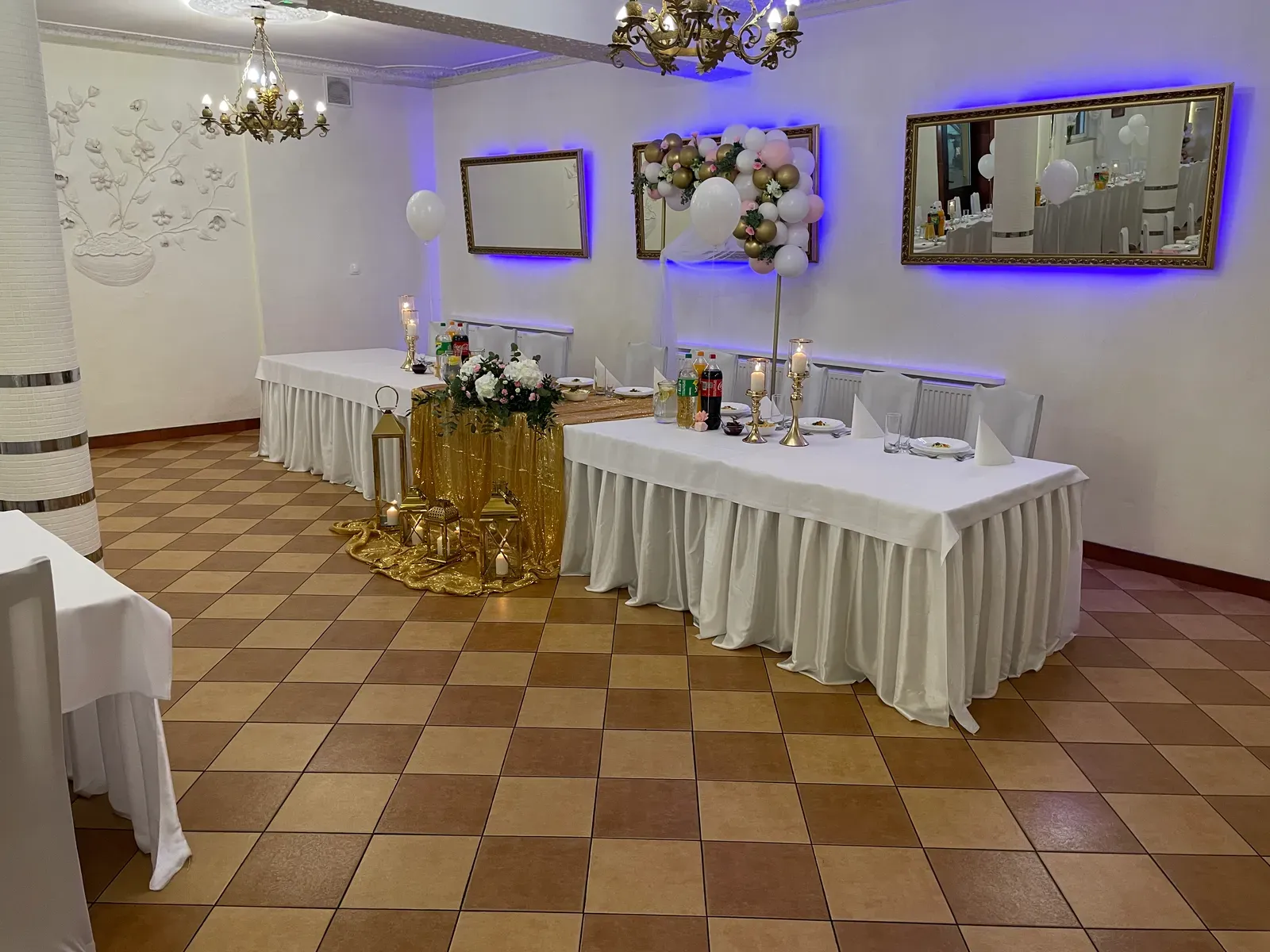 Stół pary młodej z kompozycją kwiatową i lampionami