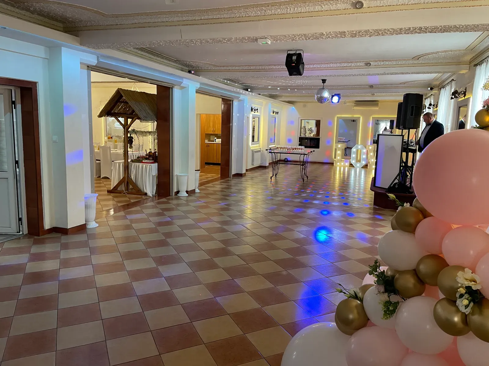 Panorama sali bankietowej z wiejskim stołem pod strzechą