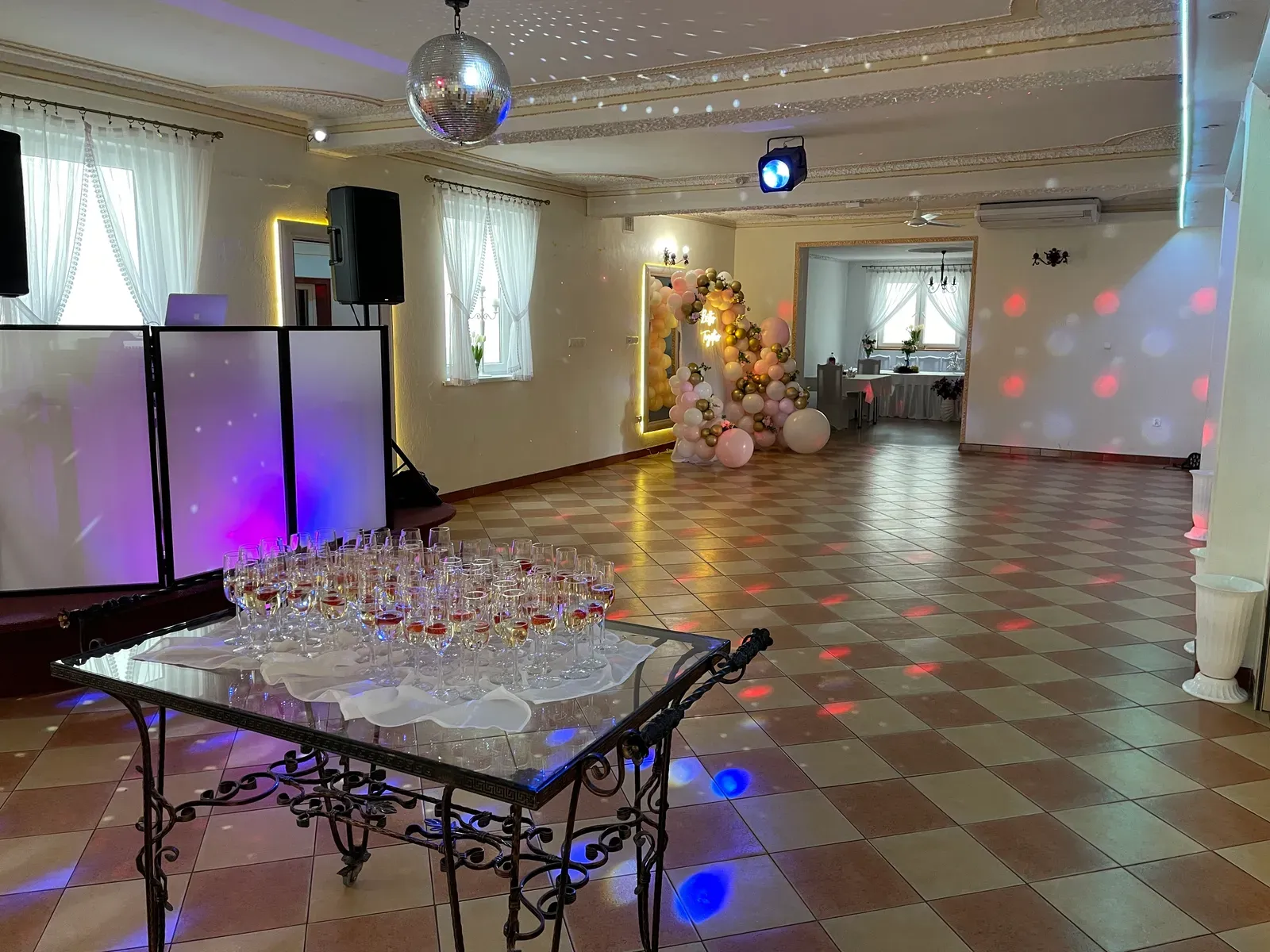 Sala z parkietem, kulą lustrzaną i dekoracją balonową