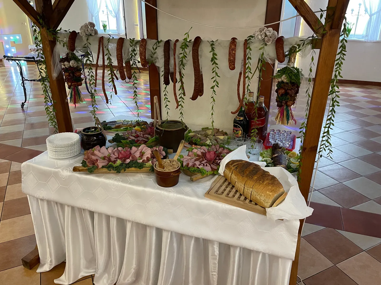 Wiejski stół i przygotowana sala przyjęć w tle