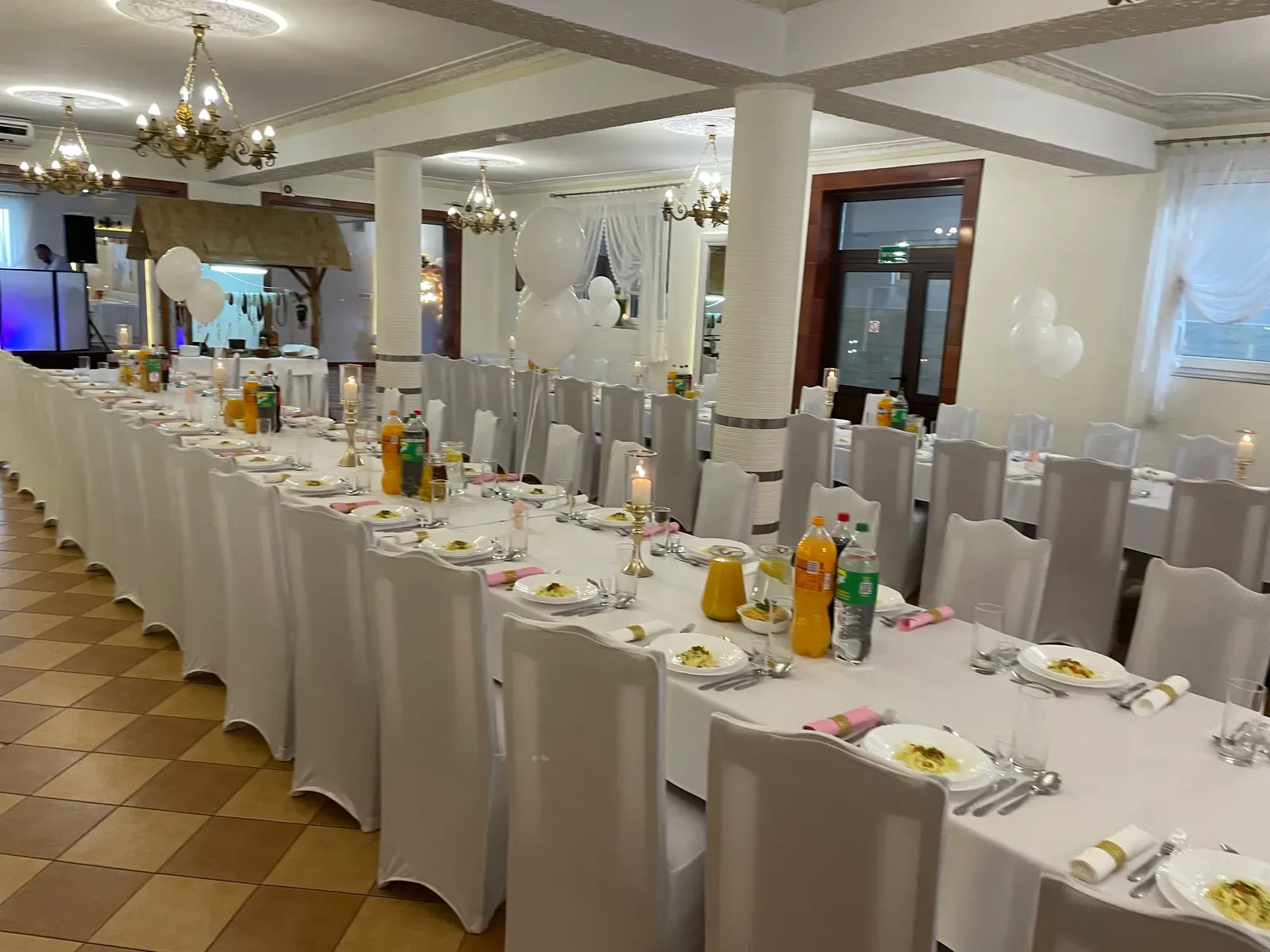 Przestronna sala z nakrytymi stołami i kolumnami