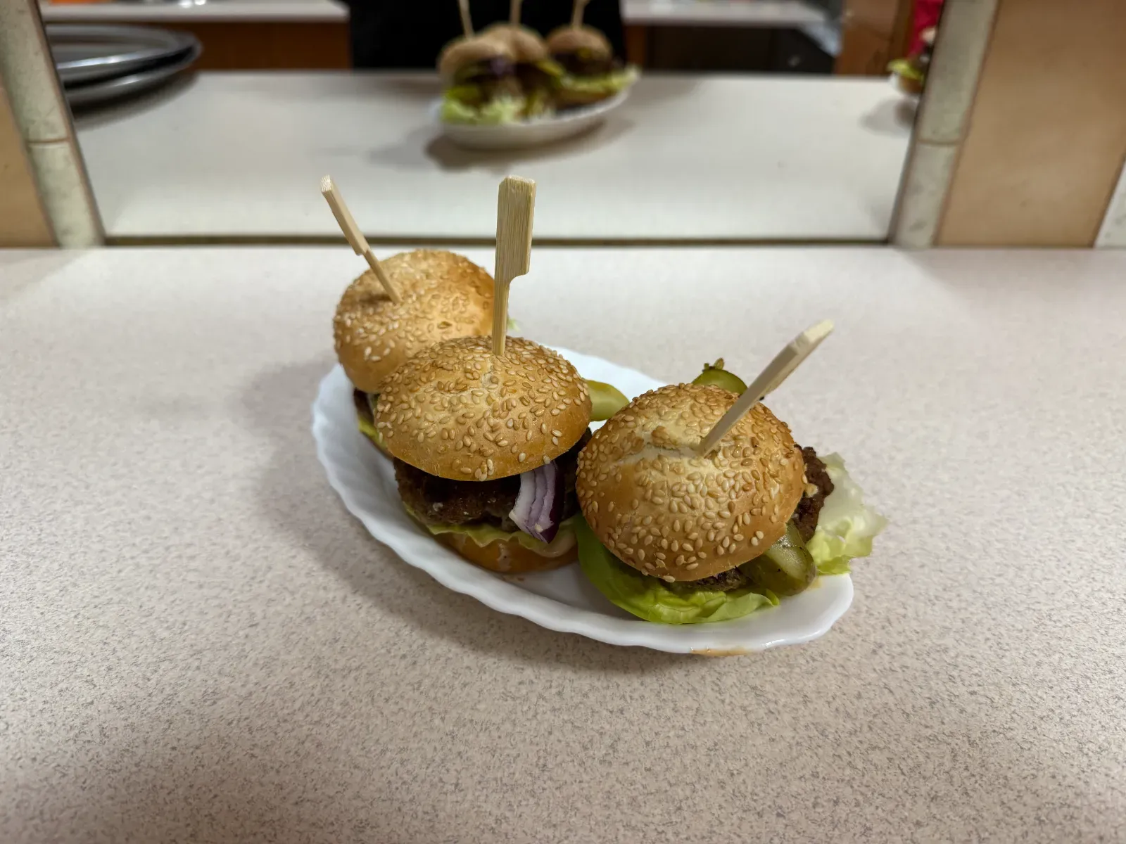 Mini burgery z sezamowymi bułkami i sałatą w kadrze z bliska