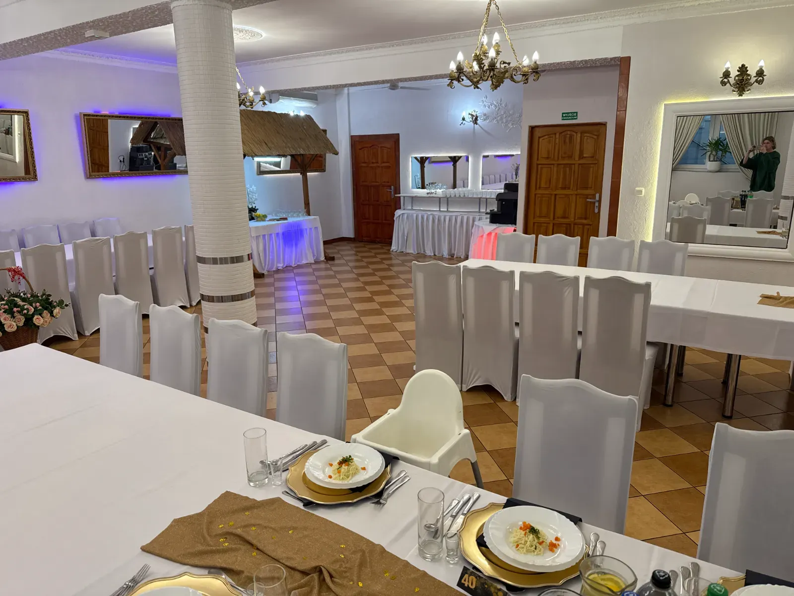 Sala z jutowymi bieżnikami, złotymi podtalerzami i krzesełkiem dla dziecka